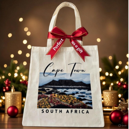 Beige Graphic Tote Bag with a view of Table Mountain fromBlaauwberg Beach with sand dunes and flora as well as the vastness of the Atlantic Ocean in Cape Town, South Africa - Tabletop Serenity by René Tesner - Product (Informative)
